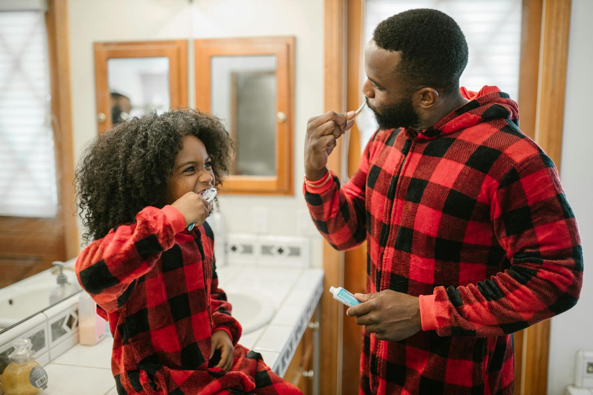Father and daughter brushing teeth